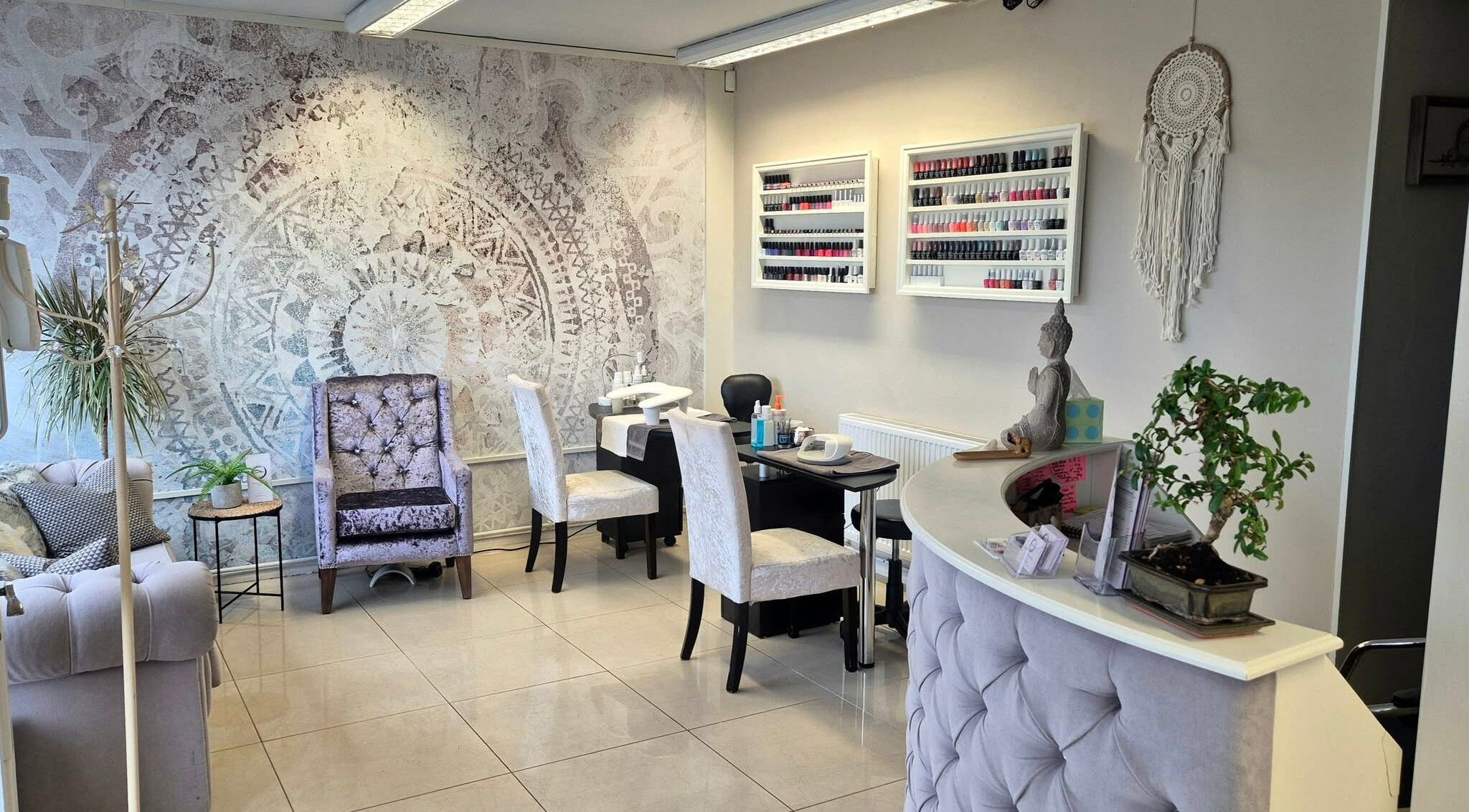 Calm interior of Zen Den Beauty and Wellbeing Centre, Humberston, GB, showcasing nail desks and plush seating.