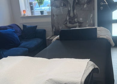 Relaxing treatment area at Glambylilymay, Hadleigh, England, GB. Features a massage bed and cozy seating.