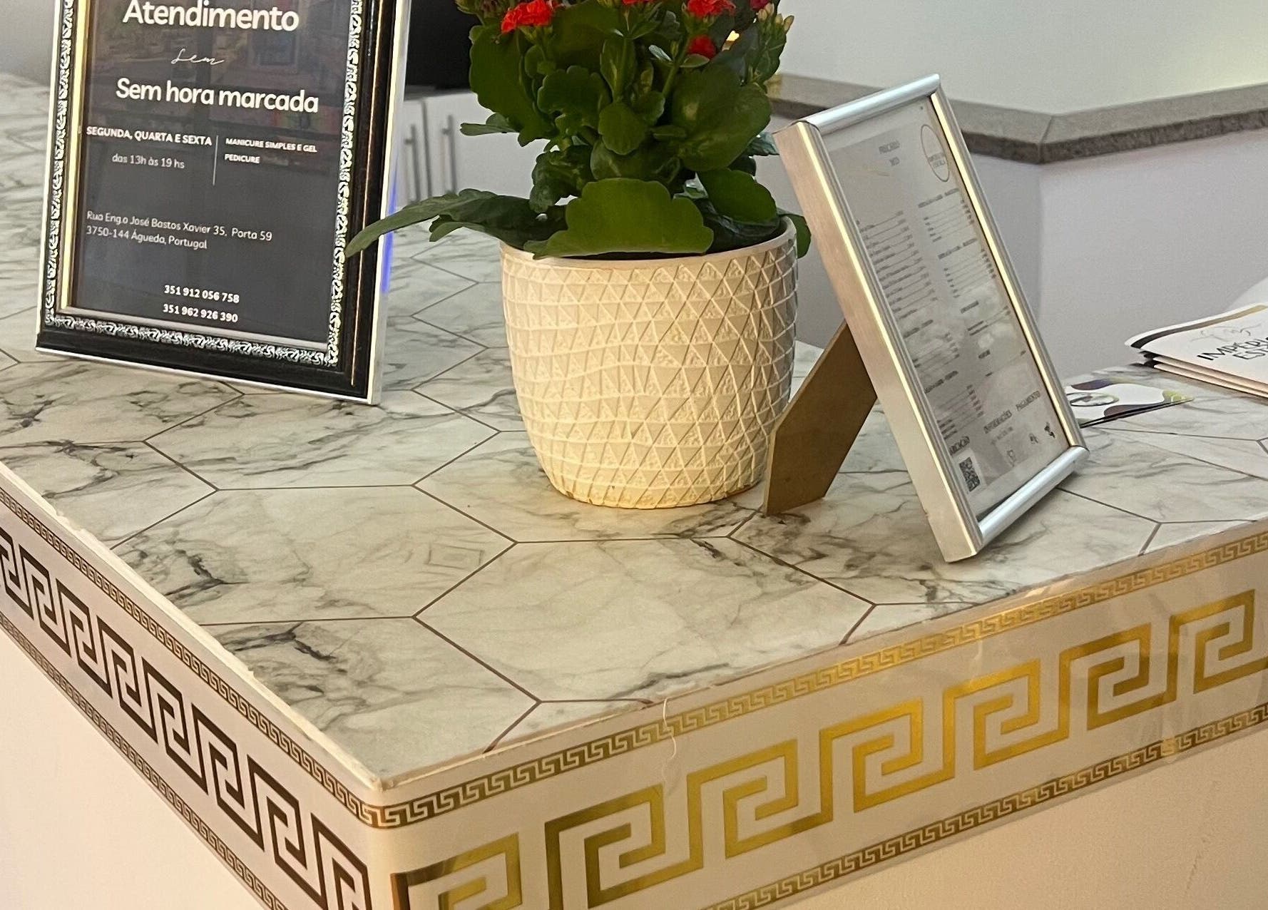 Balcão elegante na Fernanda Chaves Nails em Centro, Aveiro, PT com detalhes em mármore e decoração grega.