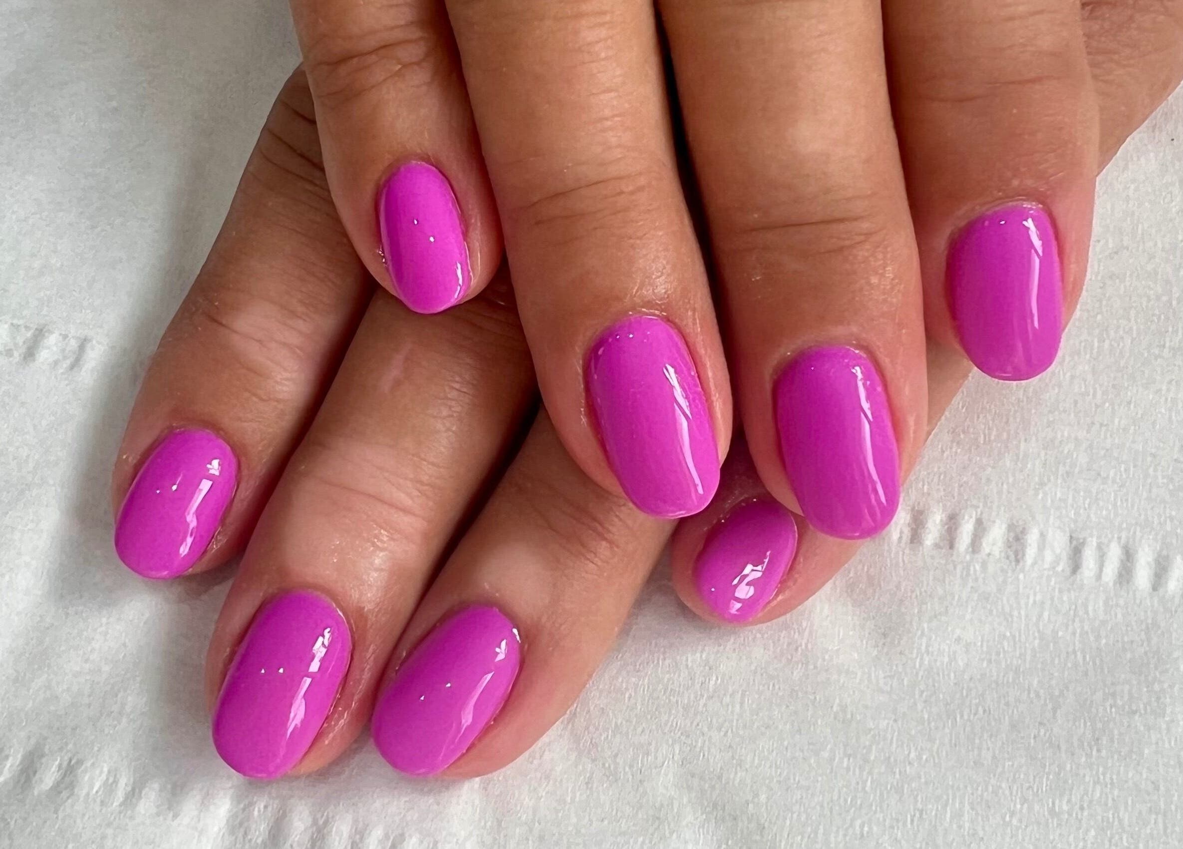 Bright violet manicure at Younger Beauty, Preston, England, GB. Perfectly polished and vibrant nail art.