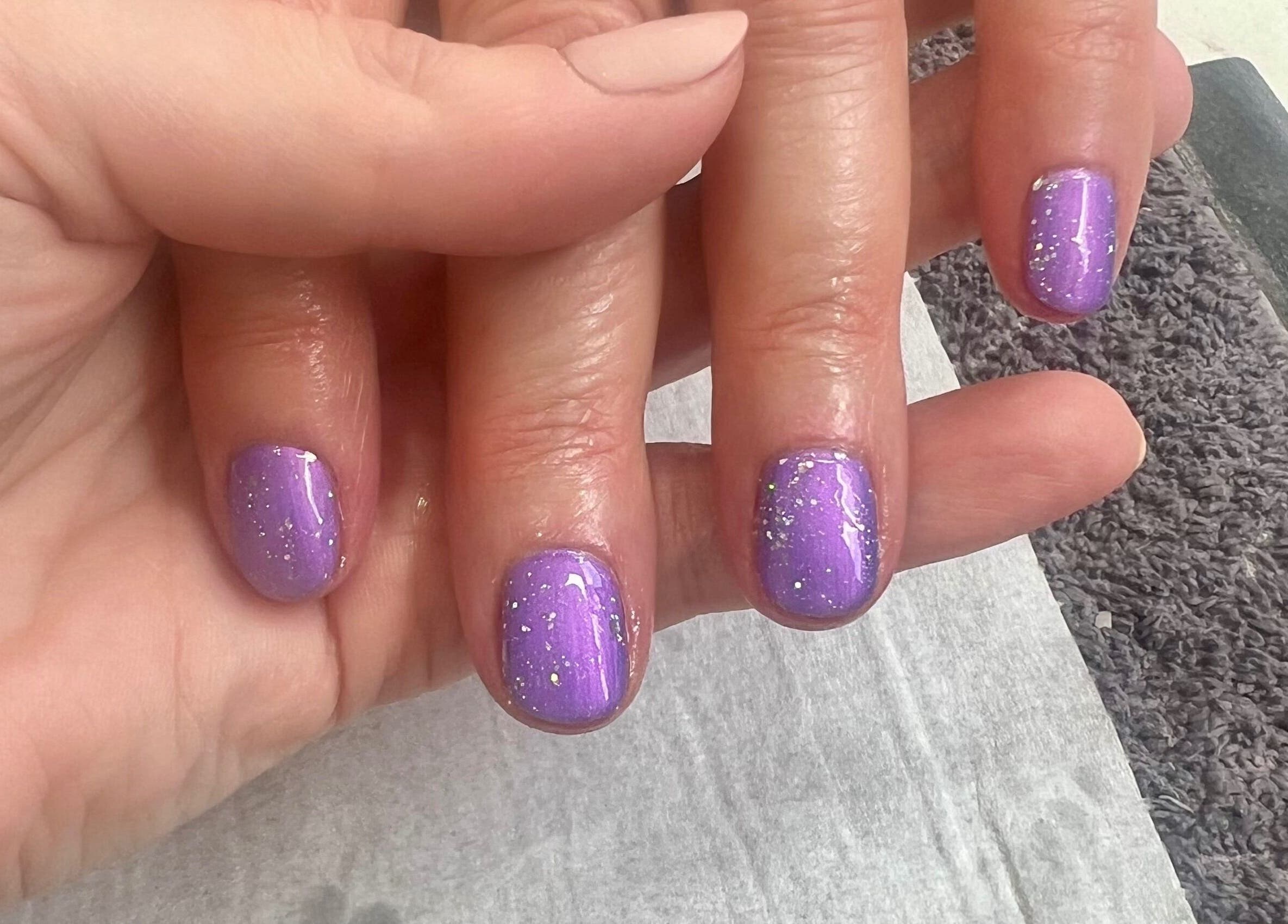 Purple glitter nails at Younger Beauty, Preston, England, GB showcasing professional manicure.