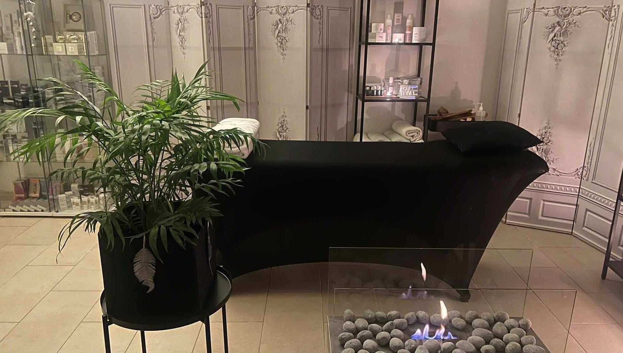 Relaxing lounge area with plant and fireplace at Alchemy Spa, Valletta, MT.