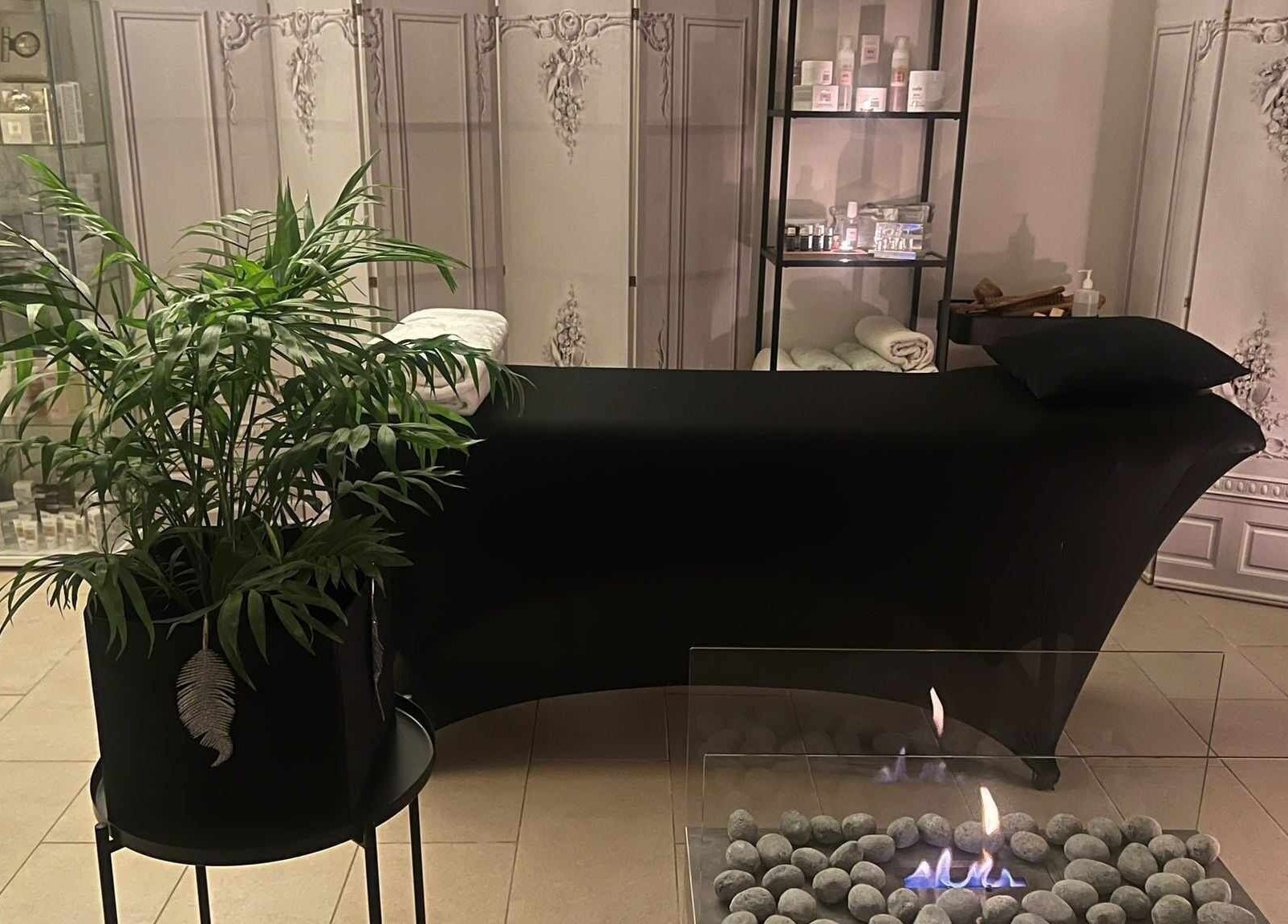 Relaxing lounge area with plant and fireplace at Alchemy Spa, Valletta, MT.