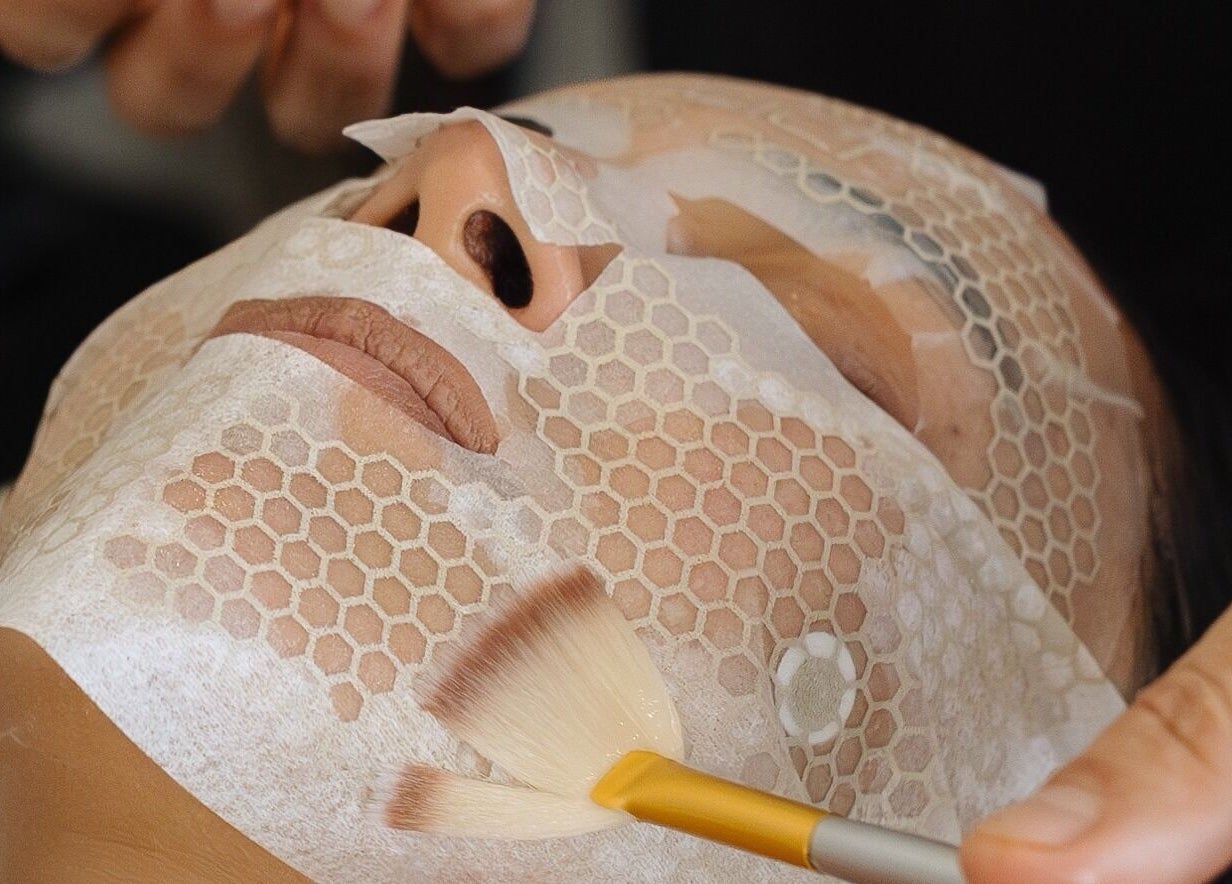 Relaxing facial treatment at Alchemy Spa, Valletta, MT using a honeycomb-pattern mask and soft brush.