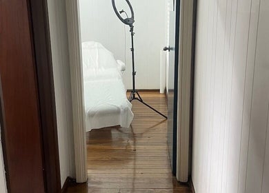 Bright treatment room at Fine Cosmetic Clinic, Auburn, New South Wales, AU, featuring a ring light and covered bed.