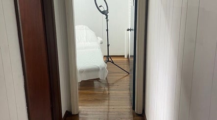 Bright treatment room at Fine Cosmetic Clinic, Auburn, New South Wales, AU, featuring a ring light and covered bed.