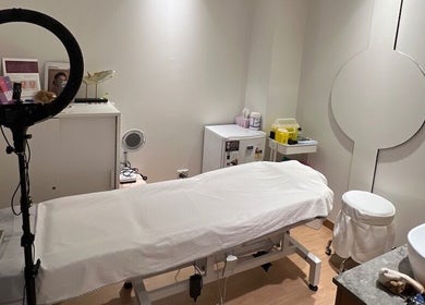 Cozy beauty treatment room at Chatswood, New South Wales, AU, with massage table and ring light setup.