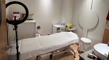 Cozy beauty treatment room at Chatswood, New South Wales, AU, with massage table and ring light setup.