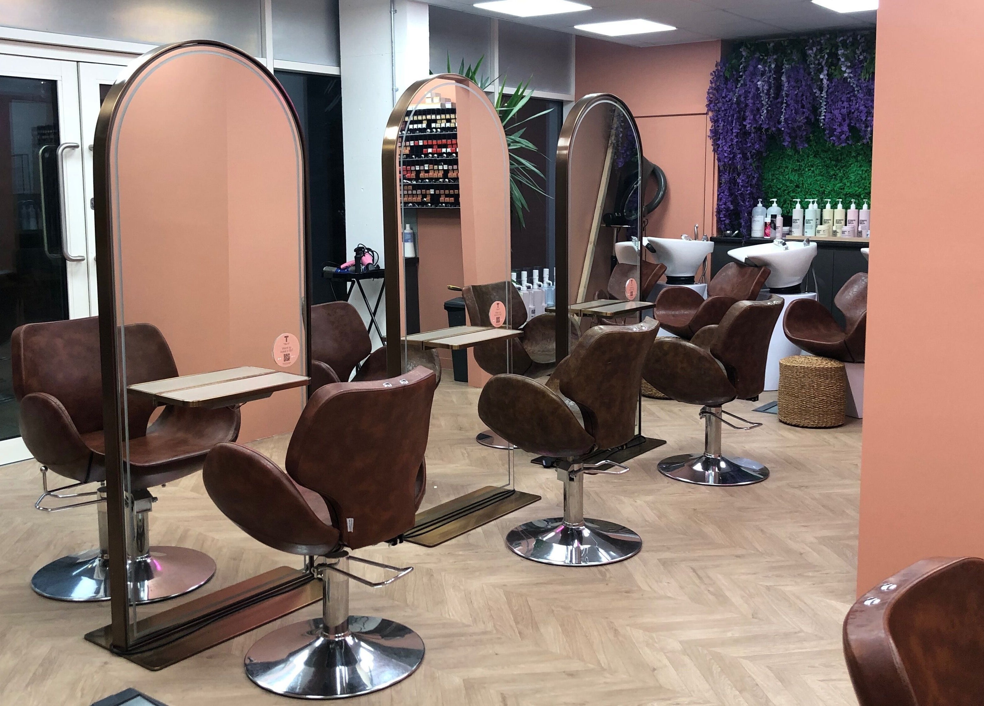 Stylish salon setup at The Tribu Collective, London, England, GB with modern chairs and vibrant decor.