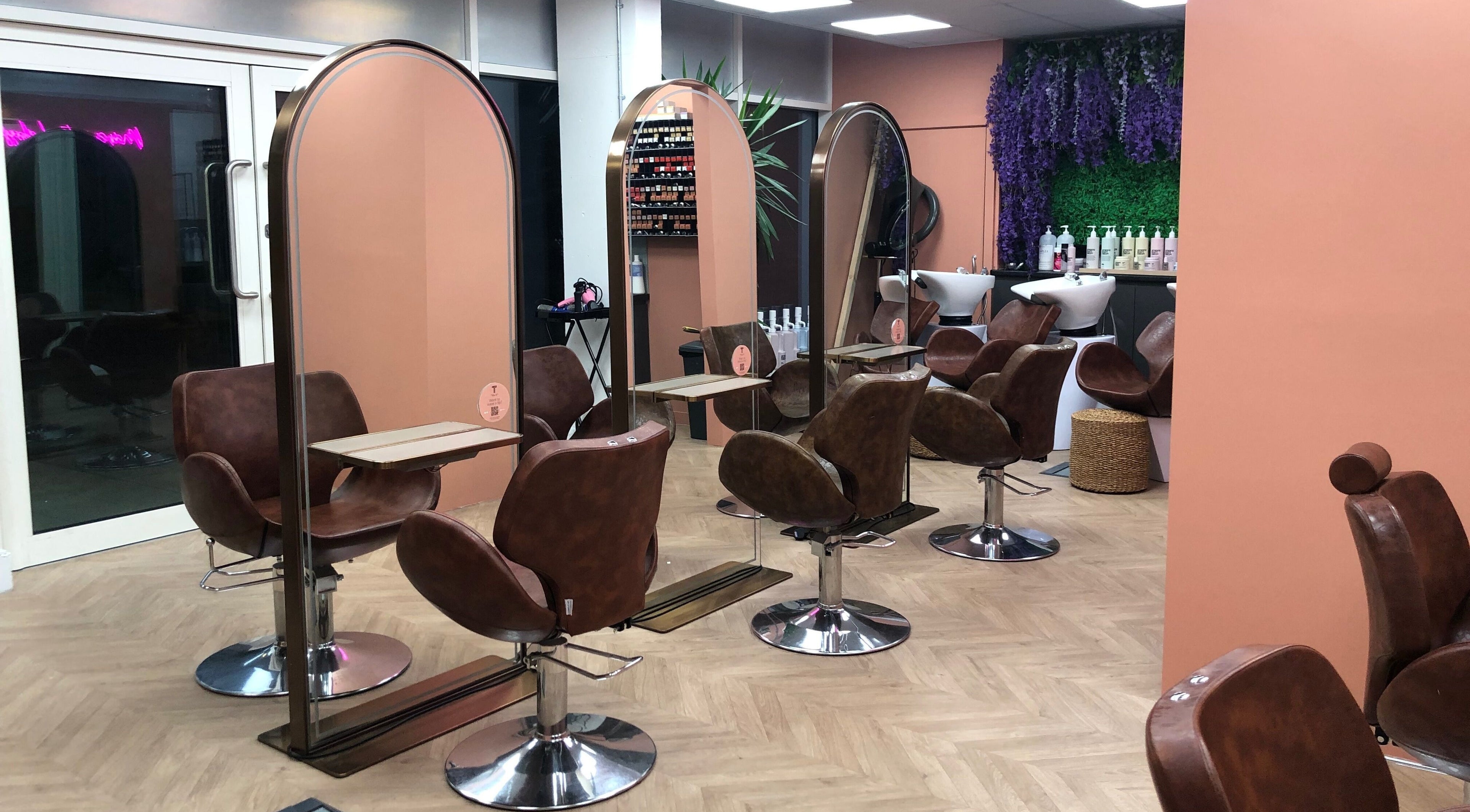 Stylish salon setup at The Tribu Collective, London, England, GB with modern chairs and vibrant decor.