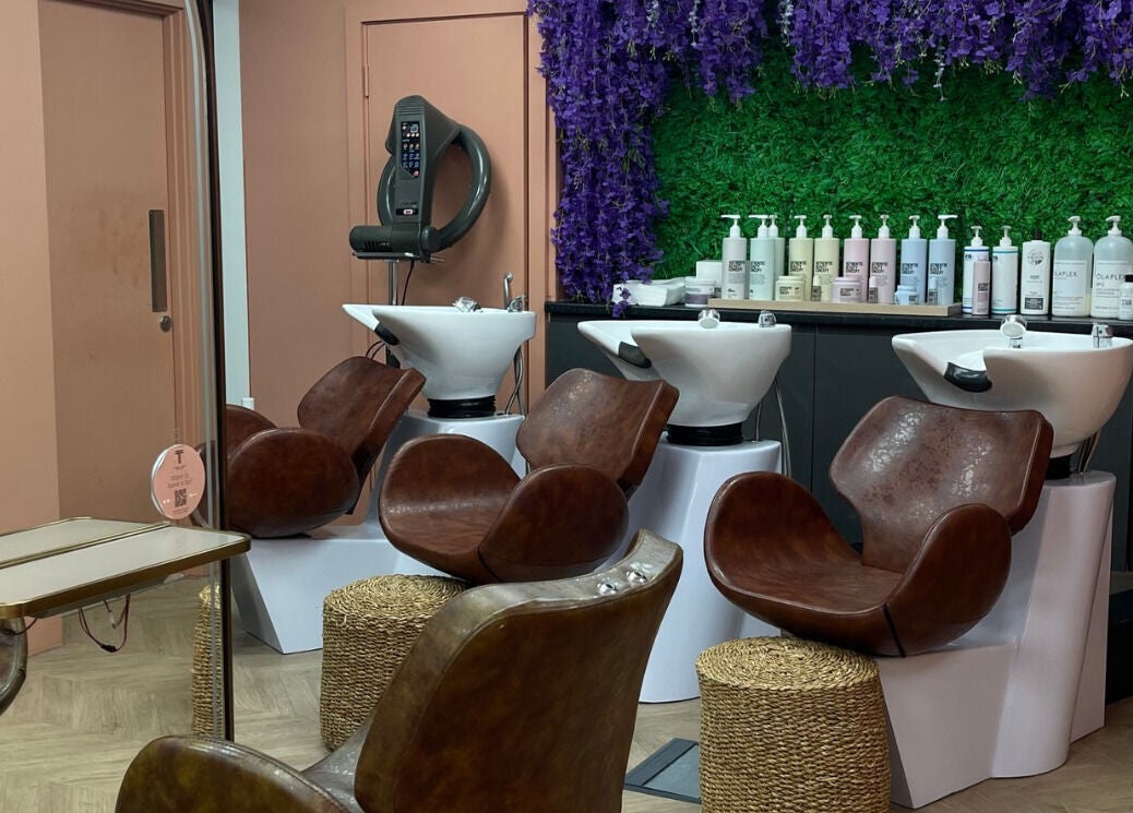 Chic salon at The Tribu Collective in London, England, GB with modern hair wash stations and vibrant decor.