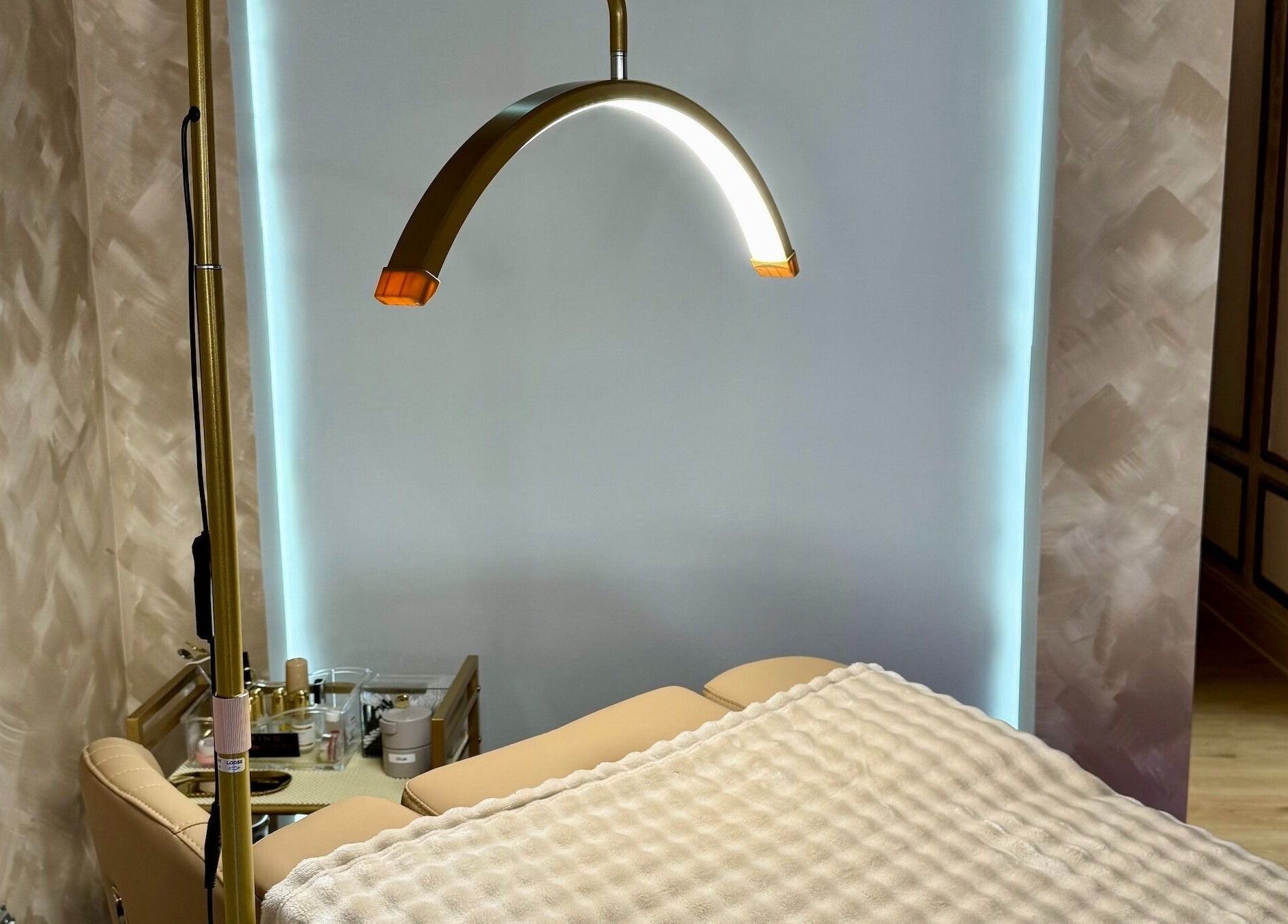 Relaxing spa treatment room at Garden and Bee, Eatontown, New Jersey, US, featuring cozy massage bed and warm lighting.