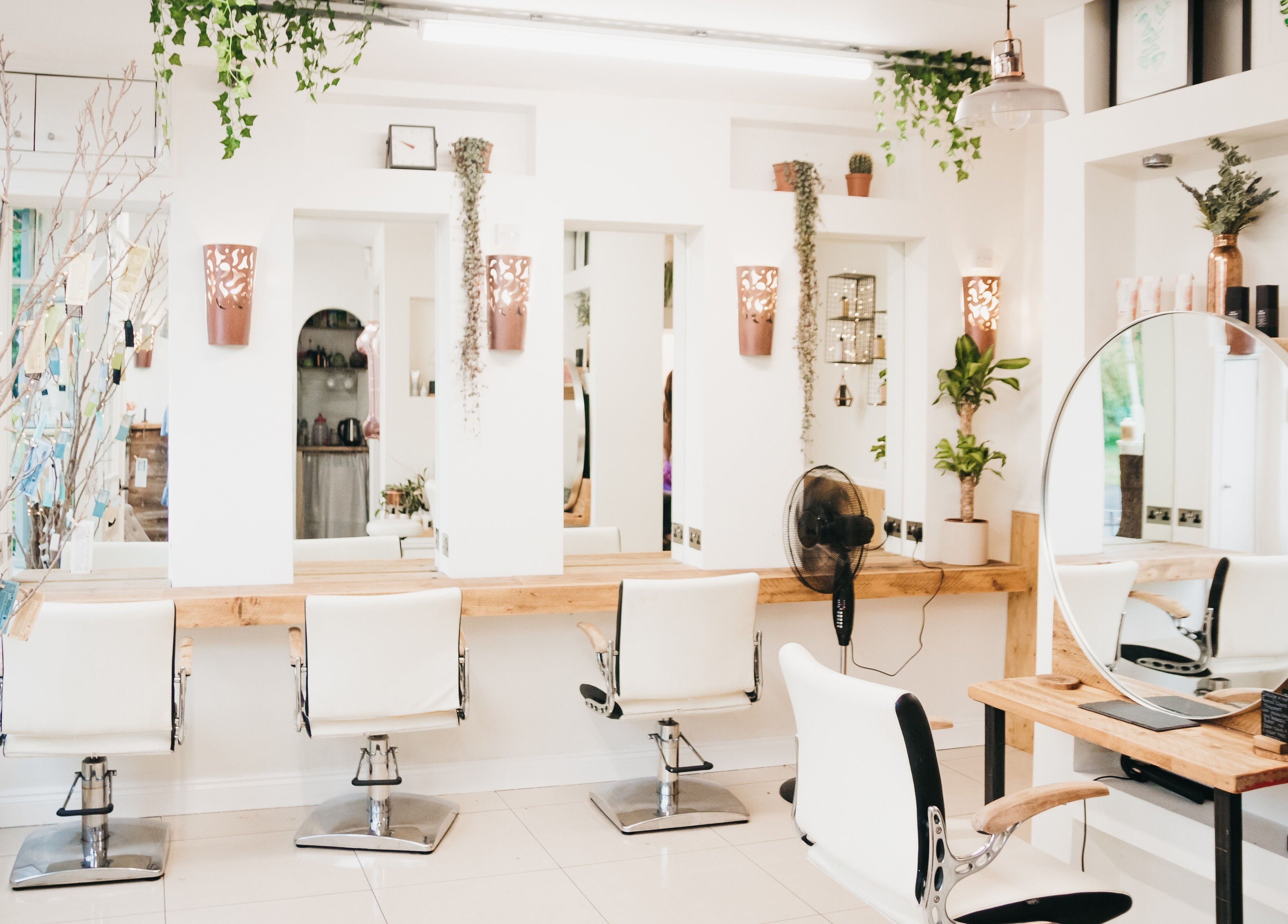 Elegant salon interior at The Root, Harpenden, England, GB featuring modern mirrors and white chairs.