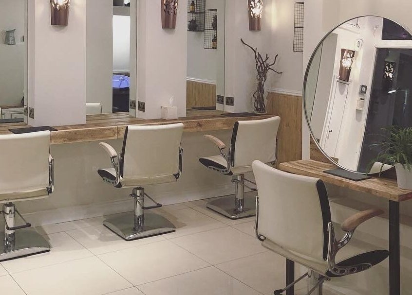 Chic hairdressing station at The Root, Harpenden, England, GB with stylish chairs and mirror setup.