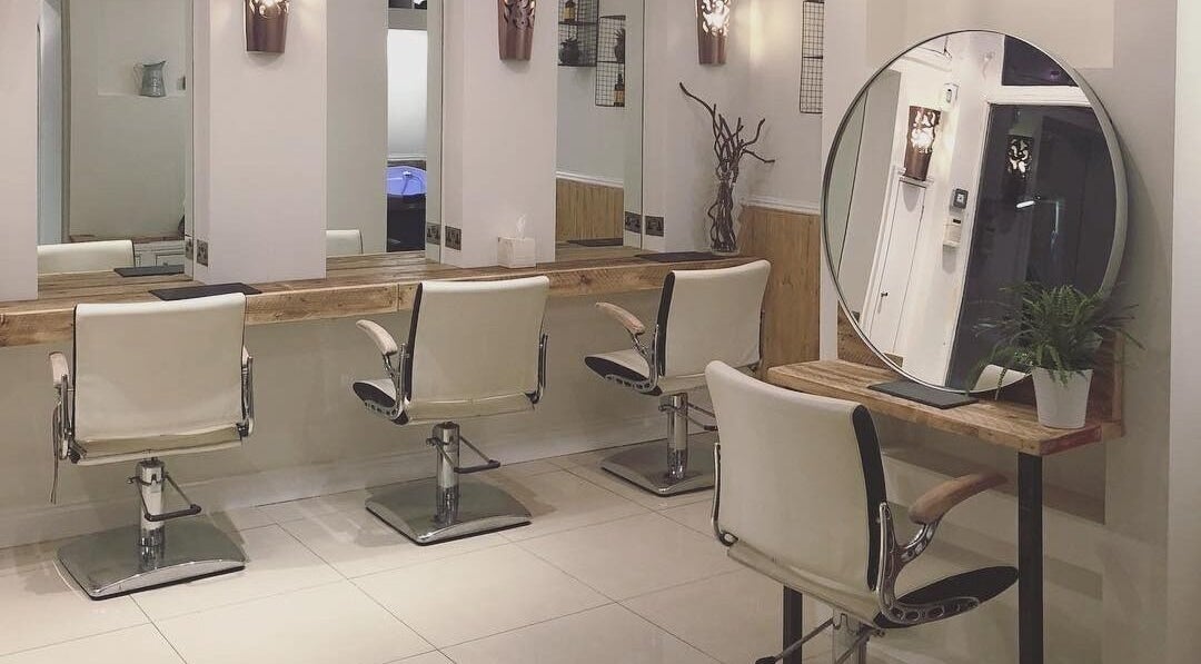 Chic hairdressing station at The Root, Harpenden, England, GB with stylish chairs and mirror setup.