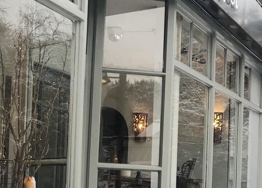 Elegant exterior of The Root, Harpenden, England, GB, with stylish glass windows reflecting serene surroundings.