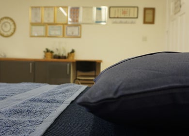 Relaxing treatment room at Zen Life Wellness, Linwood, Scotland, GB with soft lighting and blue towels.