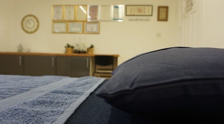 Relaxing treatment room at Zen Life Wellness, Linwood, Scotland, GB with soft lighting and blue towels.