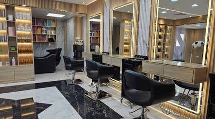Modern styling stations inside Fairy Queen Beauty Salon, Abu Dhabi, AE with sleek black chairs and illuminated mirrors.