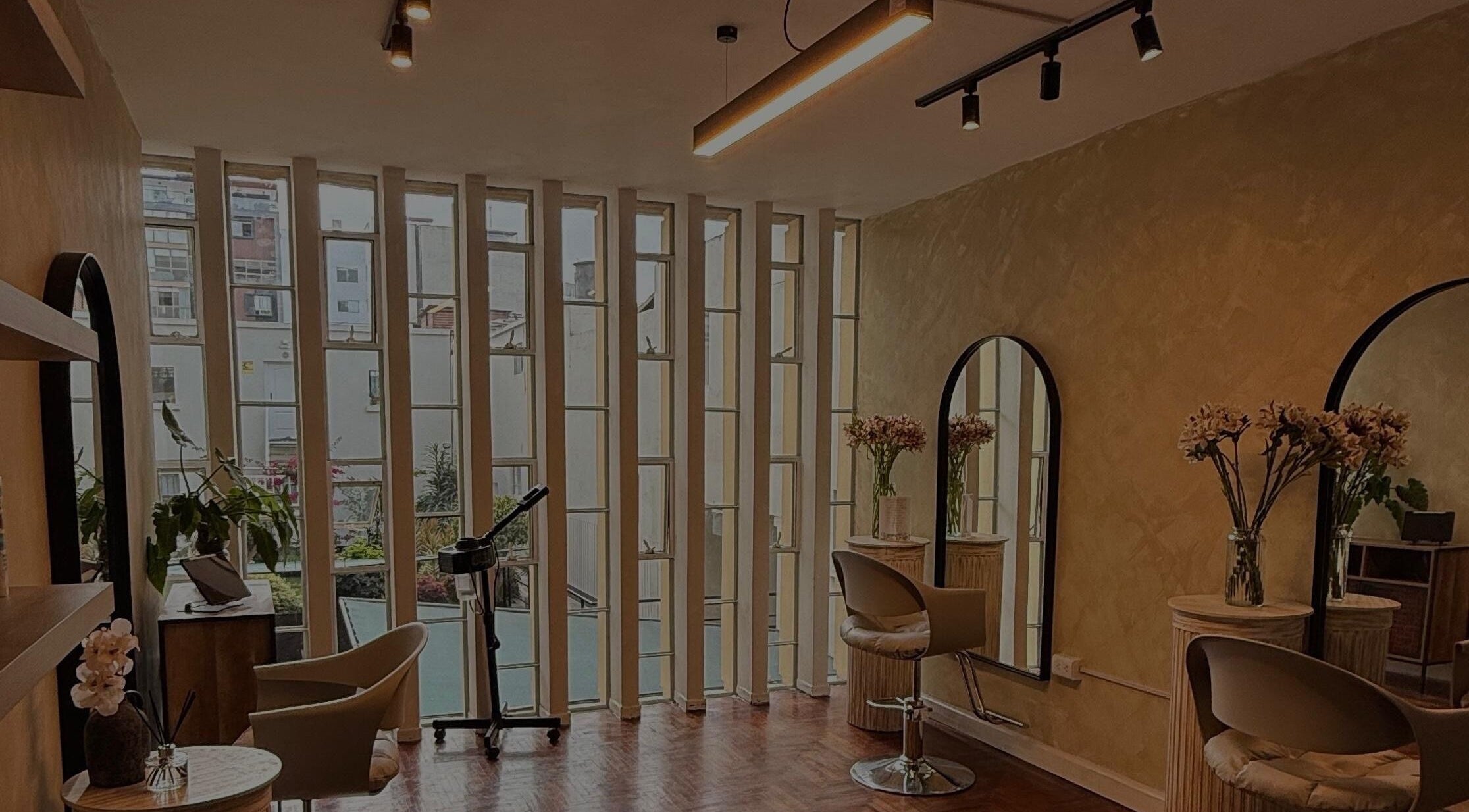 Interior moderno de Corali Cova Hair Studio en Lima, Provincia De Lima, PE, con iluminación cálida y decoración floral.