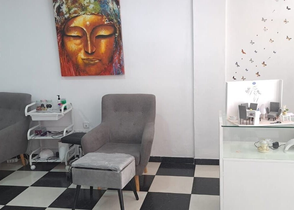 Área de relax en Estética Bella Mapi, Oliva, Comunidad Valenciana, ES con sillas grises y decoración artística.