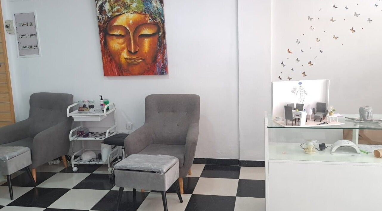 Área de relax en Estética Bella Mapi, Oliva, Comunidad Valenciana, ES con sillas grises y decoración artística.