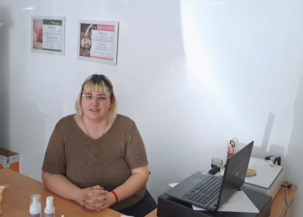 Recepcionista sonriente en Estética Bella Mapi, Oliva, Comunidad Valenciana, ES. Ambiente acogedor y profesional.