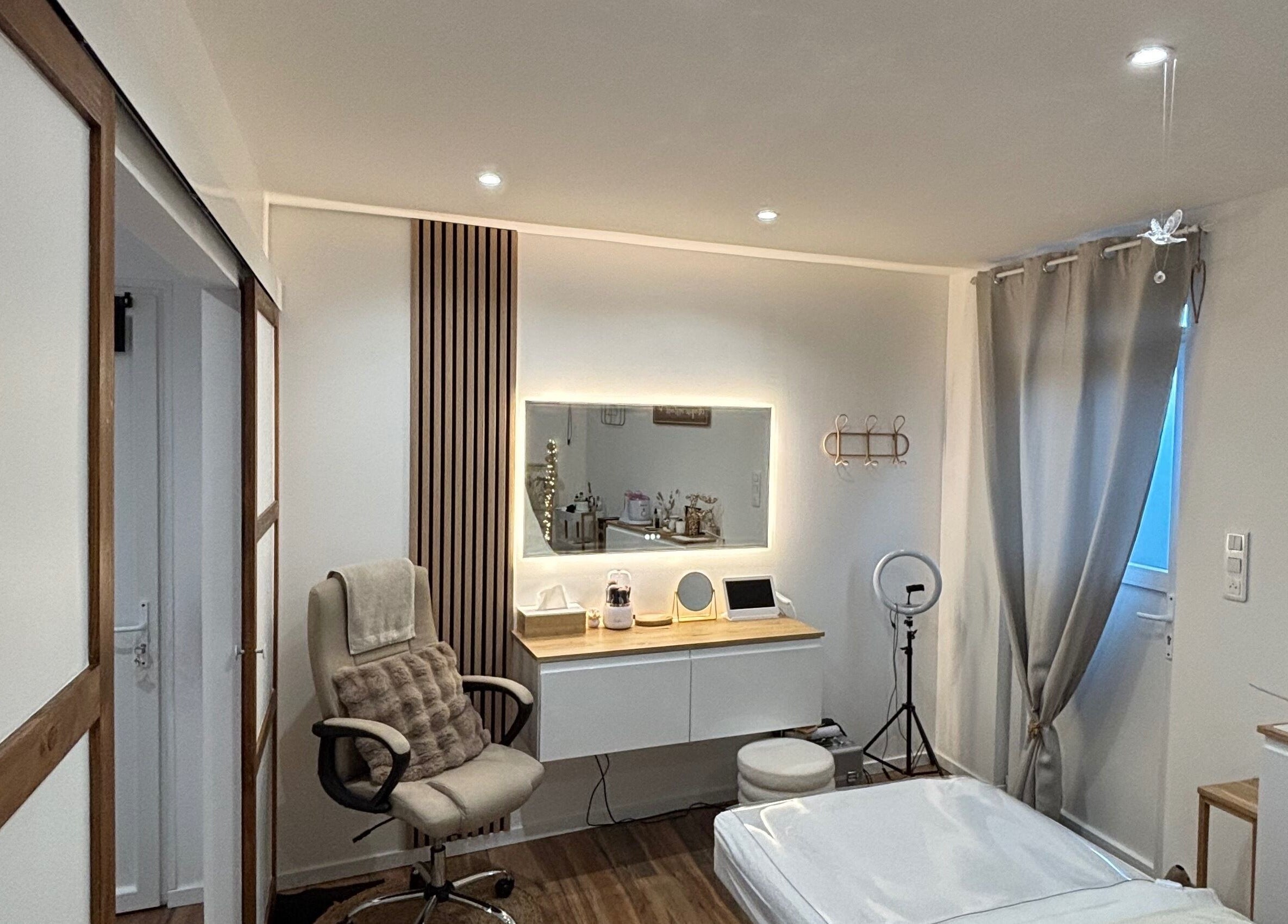 Intérieur élégant chez MILANOA ESTHÉTIQUE à Vergaville, Grand Est, FR avec fauteuil et miroir illuminé.