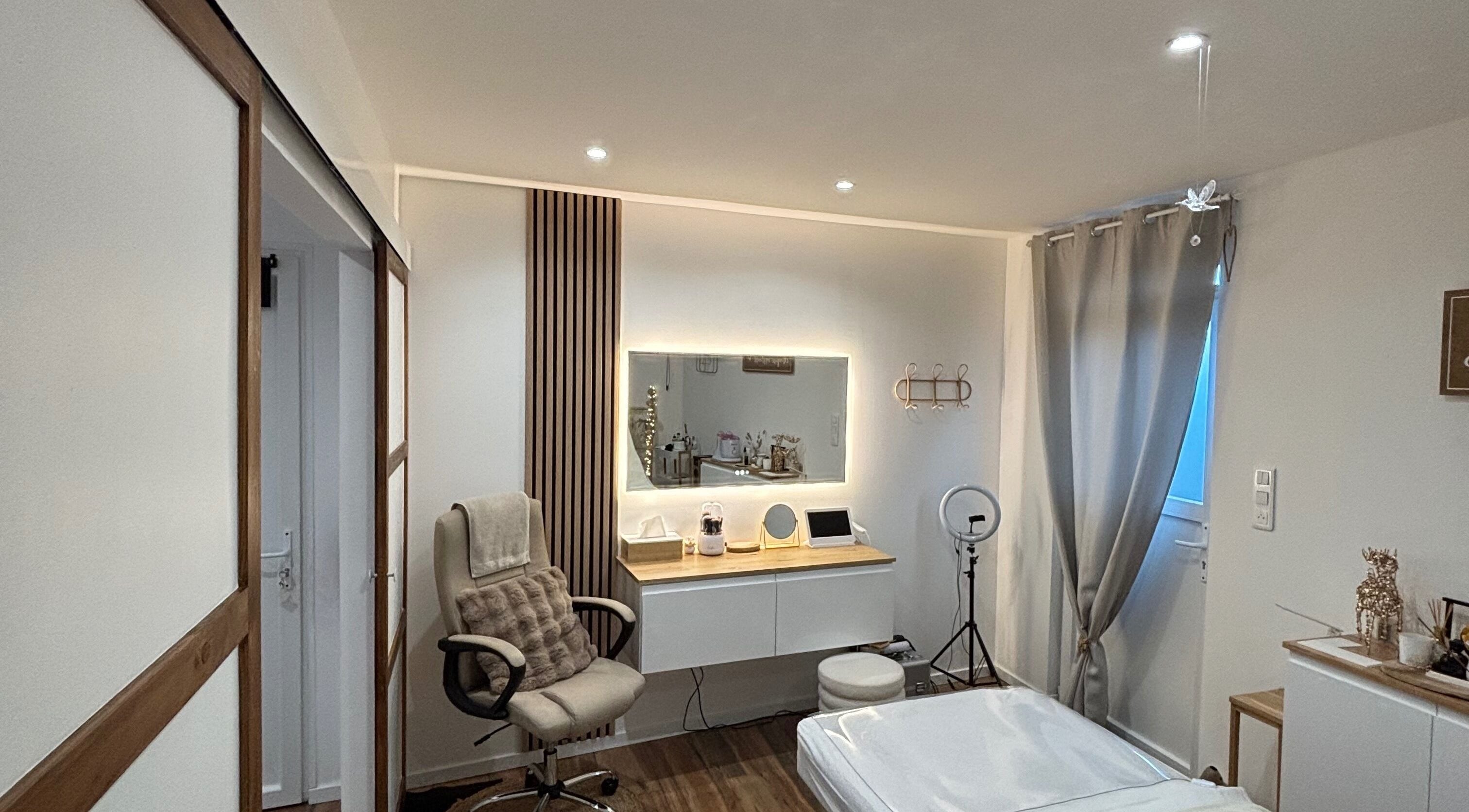 Intérieur élégant chez MILANOA ESTHÉTIQUE à Vergaville, Grand Est, FR avec fauteuil et miroir illuminé.