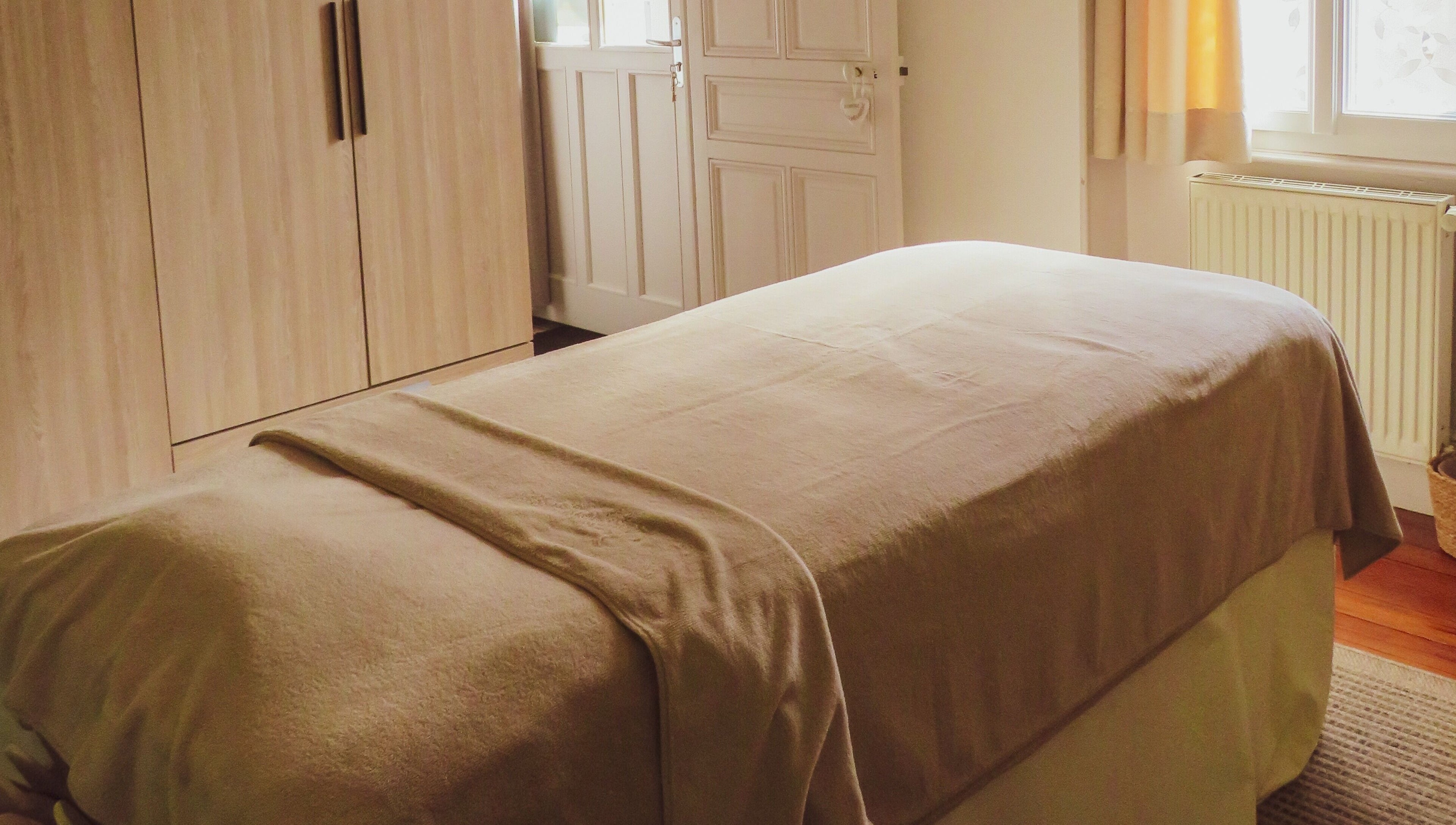 Salle de massage à Inner Beauty, Dijon, Bourgogne-Franche-Comté, FR, avec lit zen et déco apaisante.
