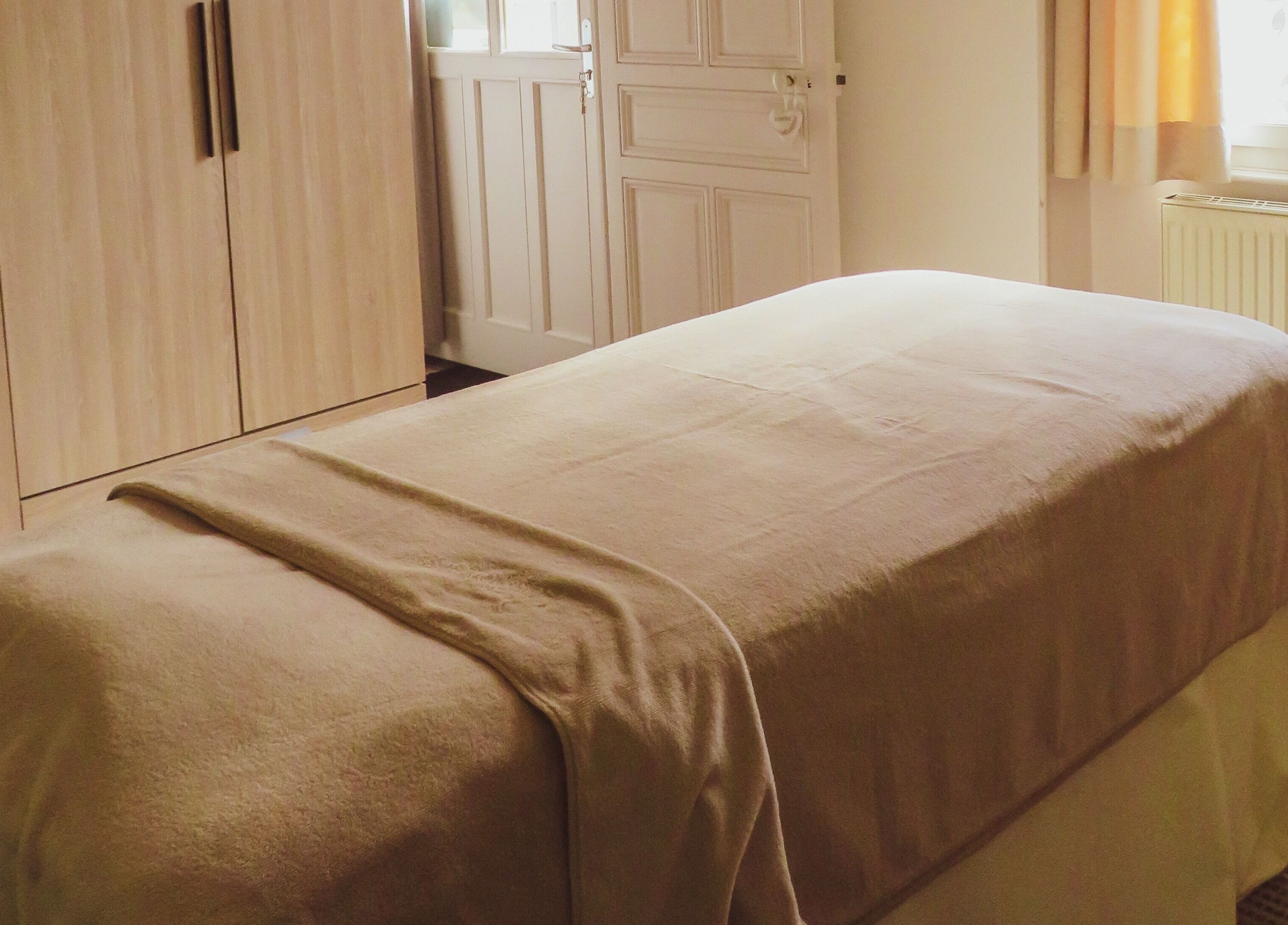 Salle de massage à Inner Beauty, Dijon, Bourgogne-Franche-Comté, FR, avec lit zen et déco apaisante.