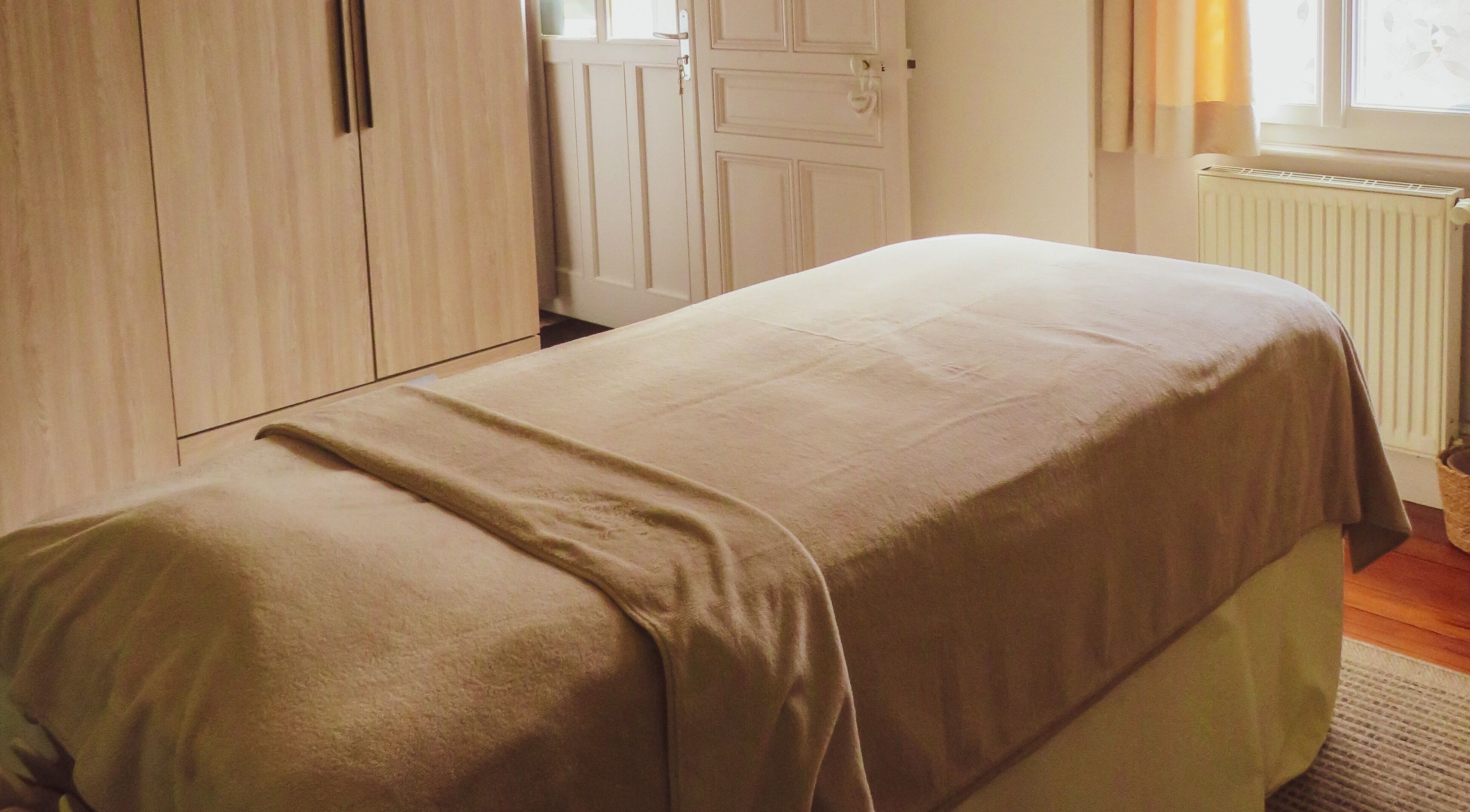 Salle de massage à Inner Beauty, Dijon, Bourgogne-Franche-Comté, FR, avec lit zen et déco apaisante.