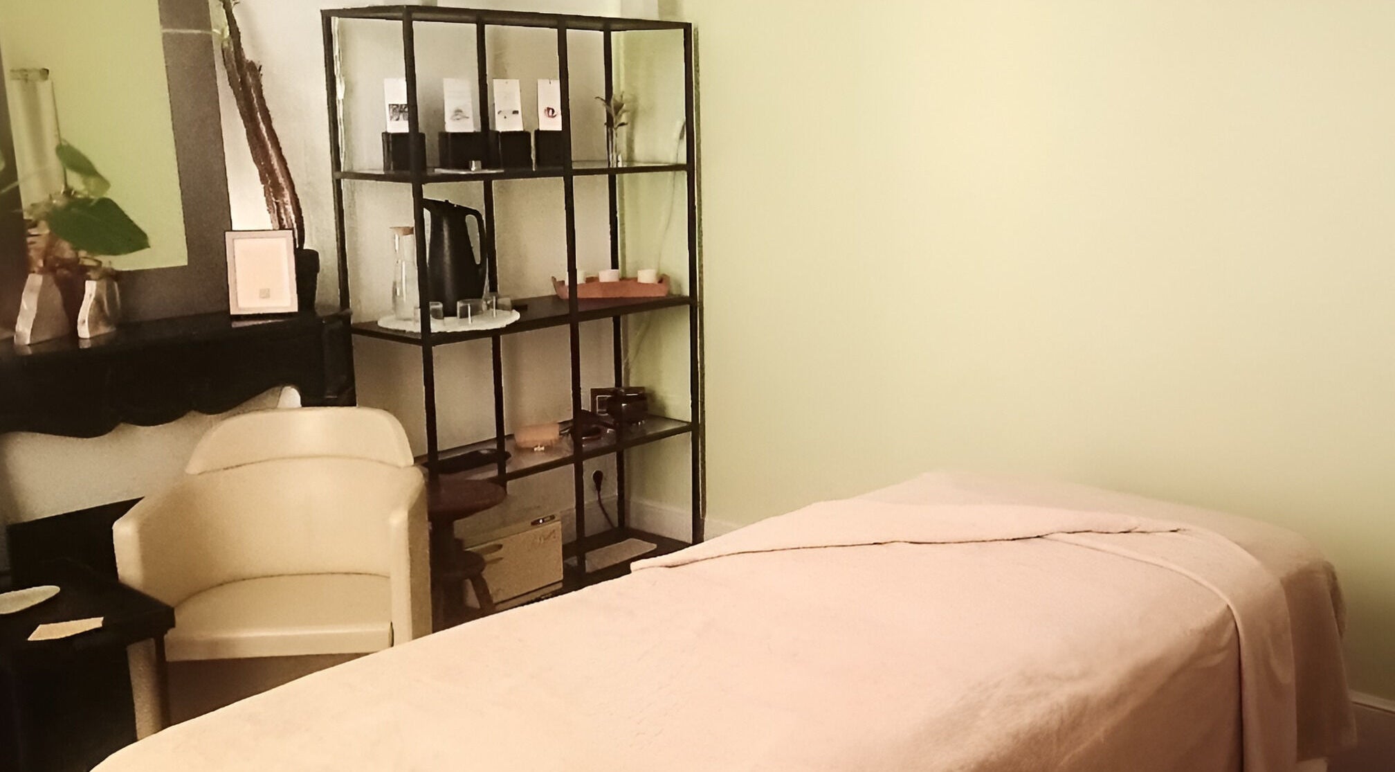 Salle de massage paisible à Inner Beauty, Dijon, Bourgogne-Franche-Comté, FR, avec table et fauteuil confortables.