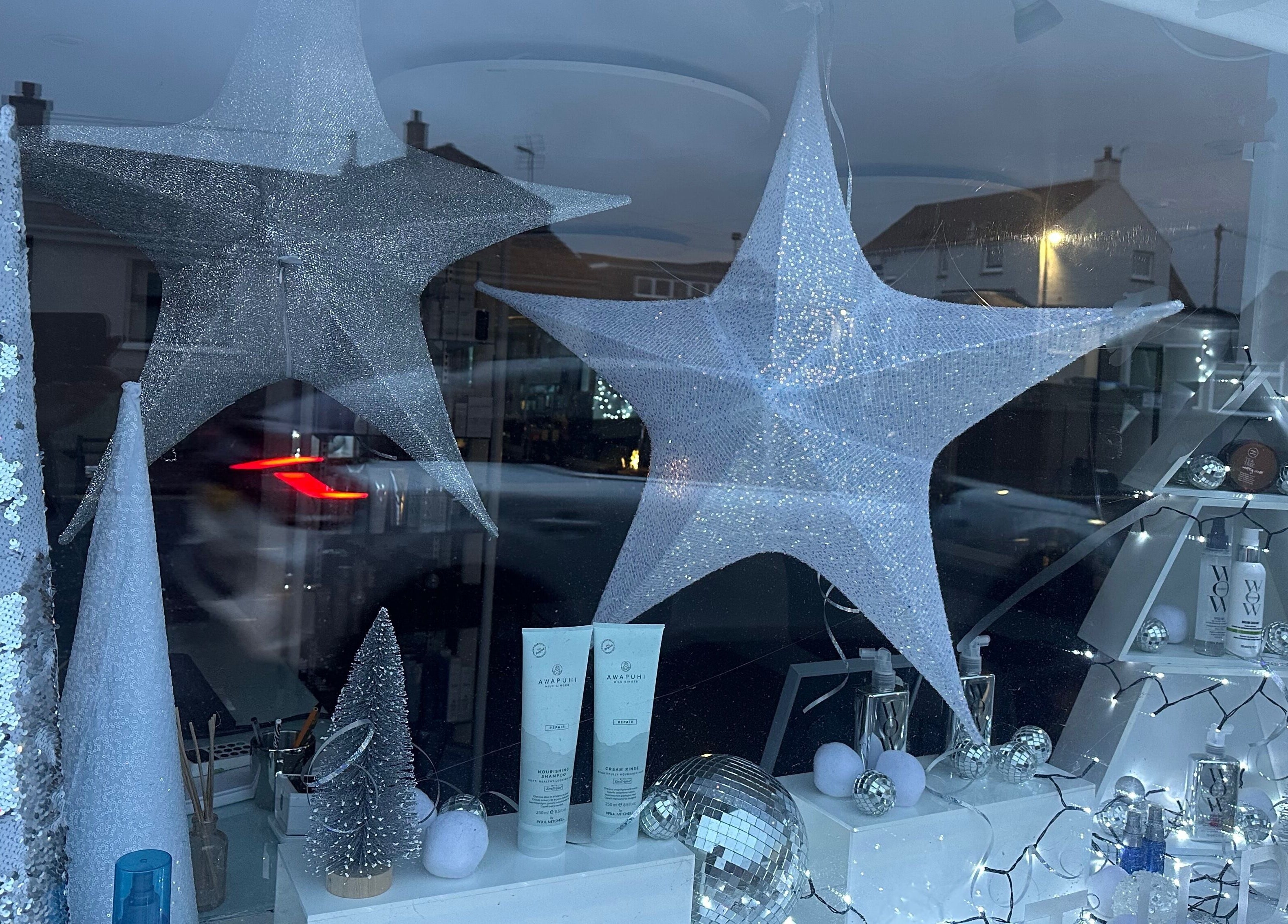 Festive star decorations at Kate Alexander Hair, Forfar, Scotland, GB, showcasing beauty products.