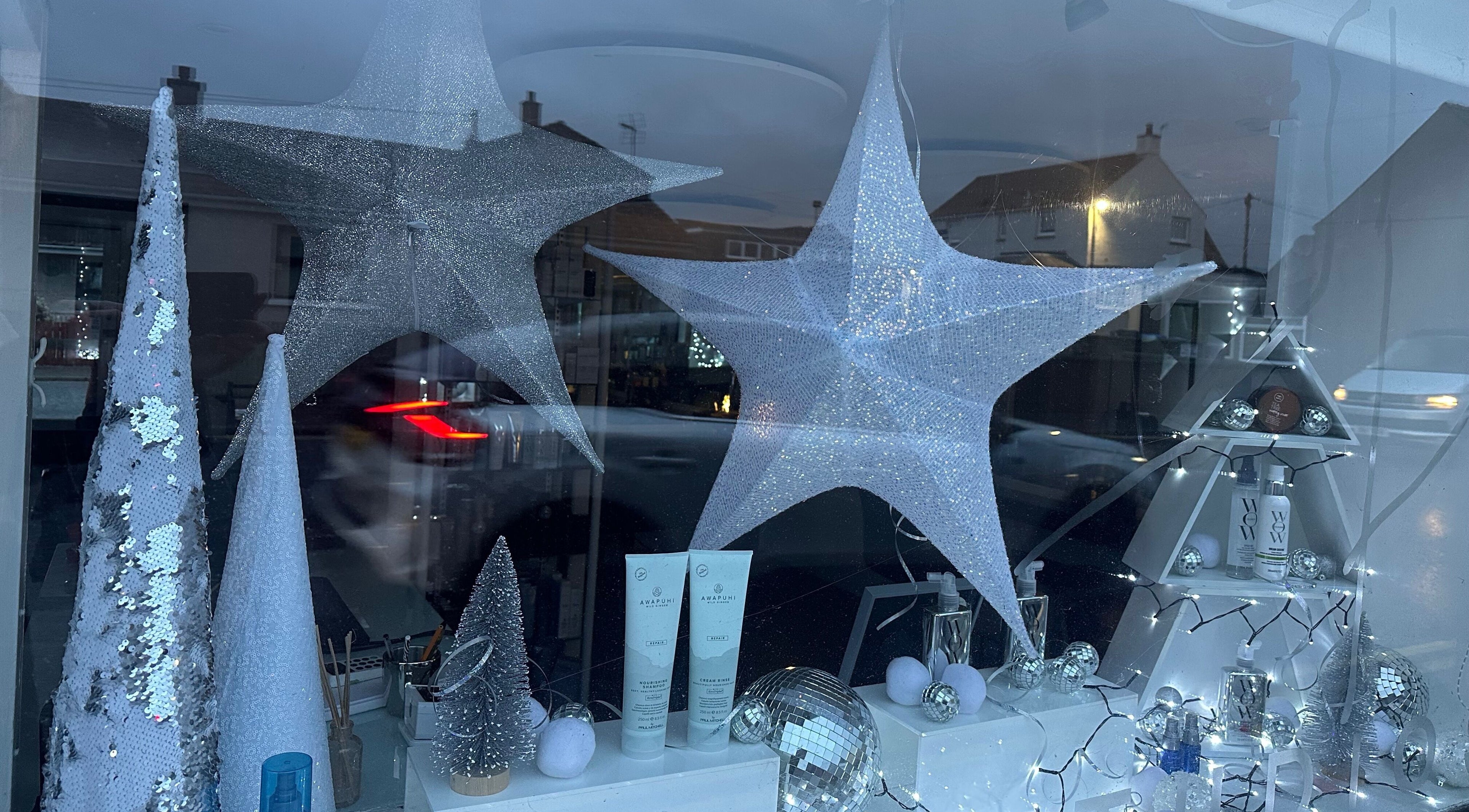 Festive star decorations at Kate Alexander Hair, Forfar, Scotland, GB, showcasing beauty products.