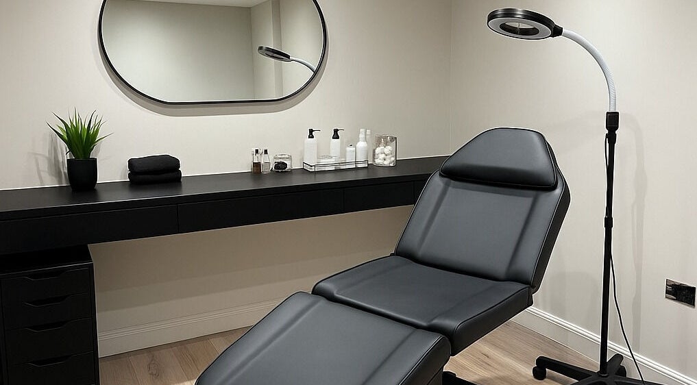 Modern treatment room at HairNova Angel, London, England, GB with sleek black furnishings and soft lighting.