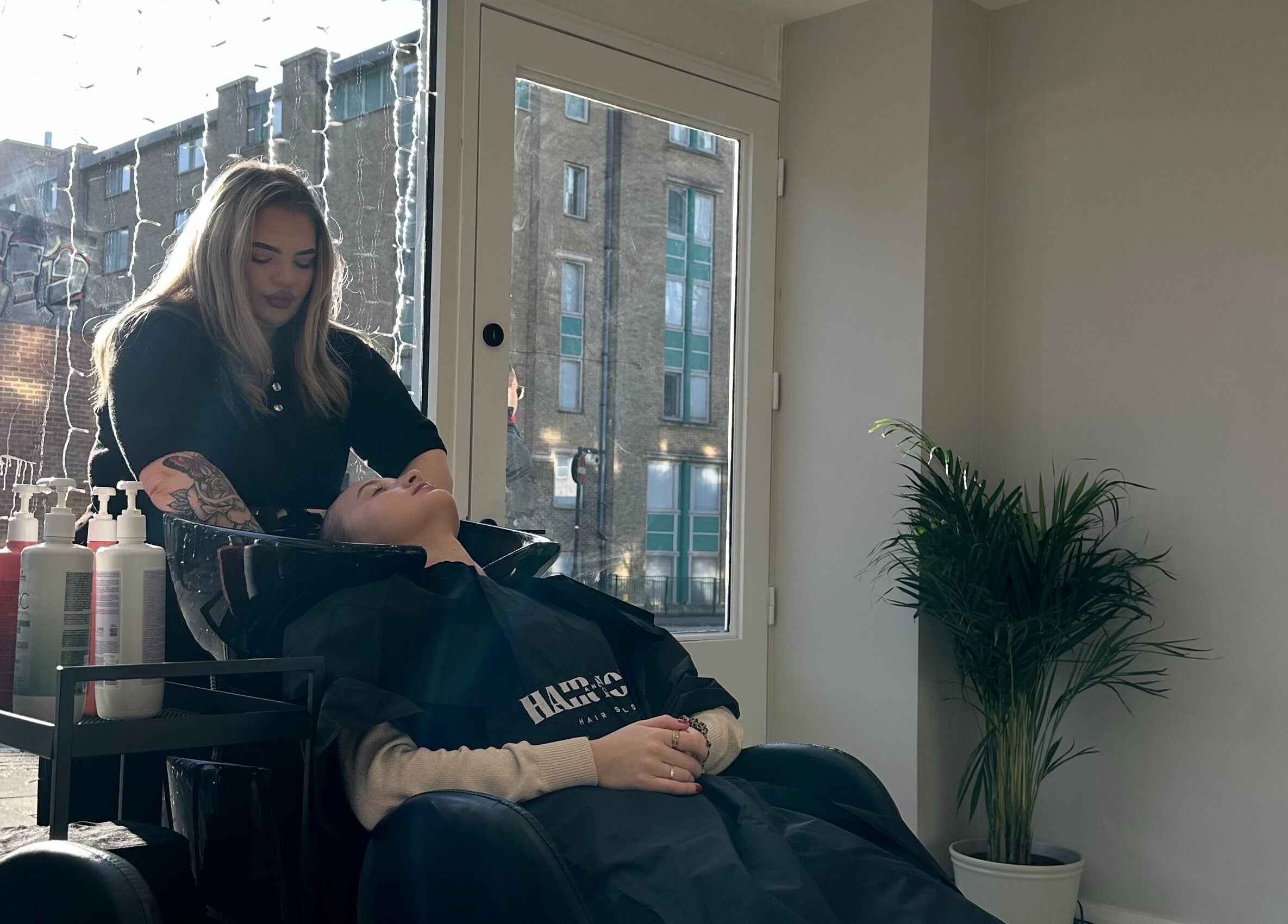 Customer enjoying hair wash at HairNova Angel, London, England, GB with soothing ambiance.