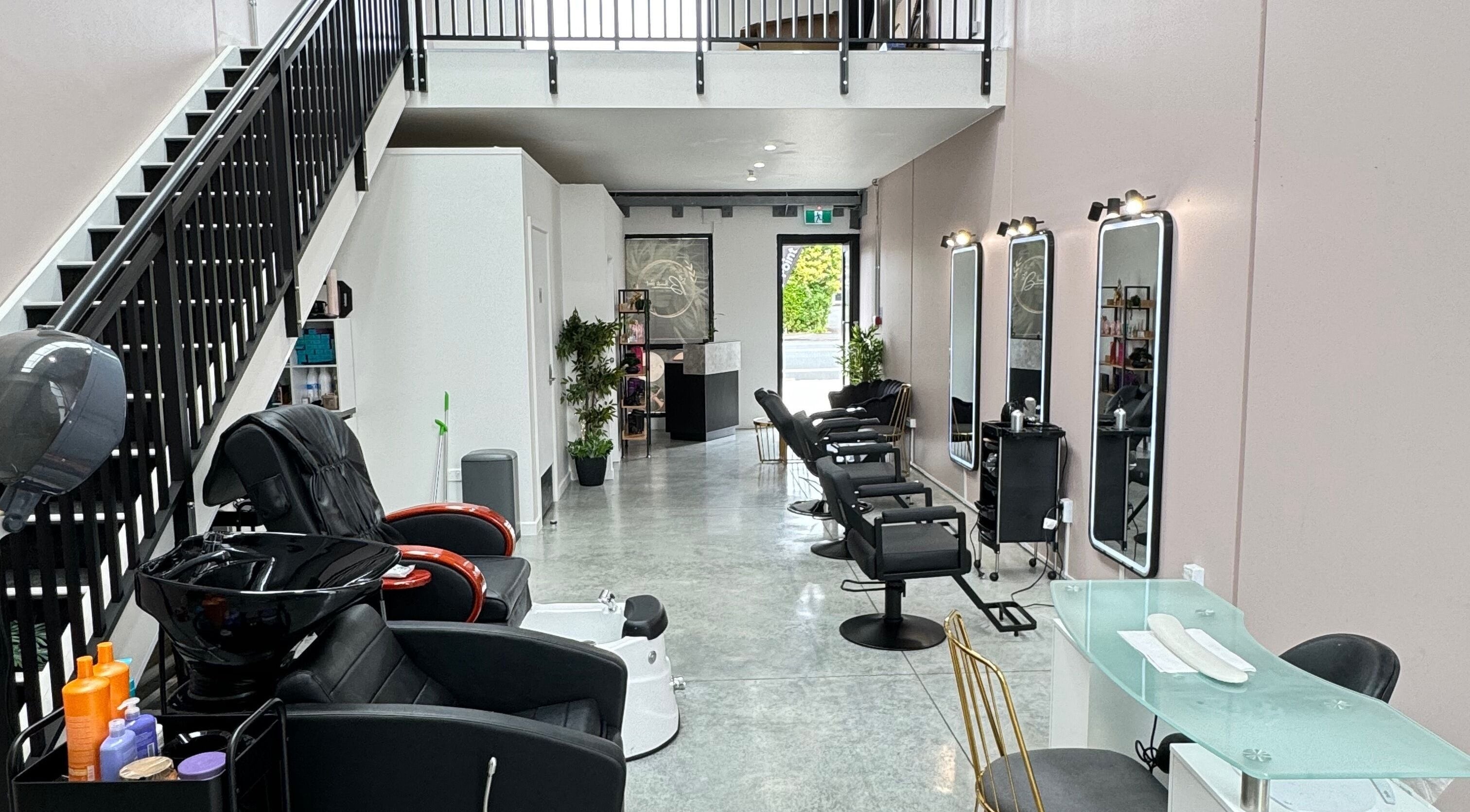 Chic interior of B Beauty Point in Auckland, NZ, showcasing modern salon chairs and sleek decor.