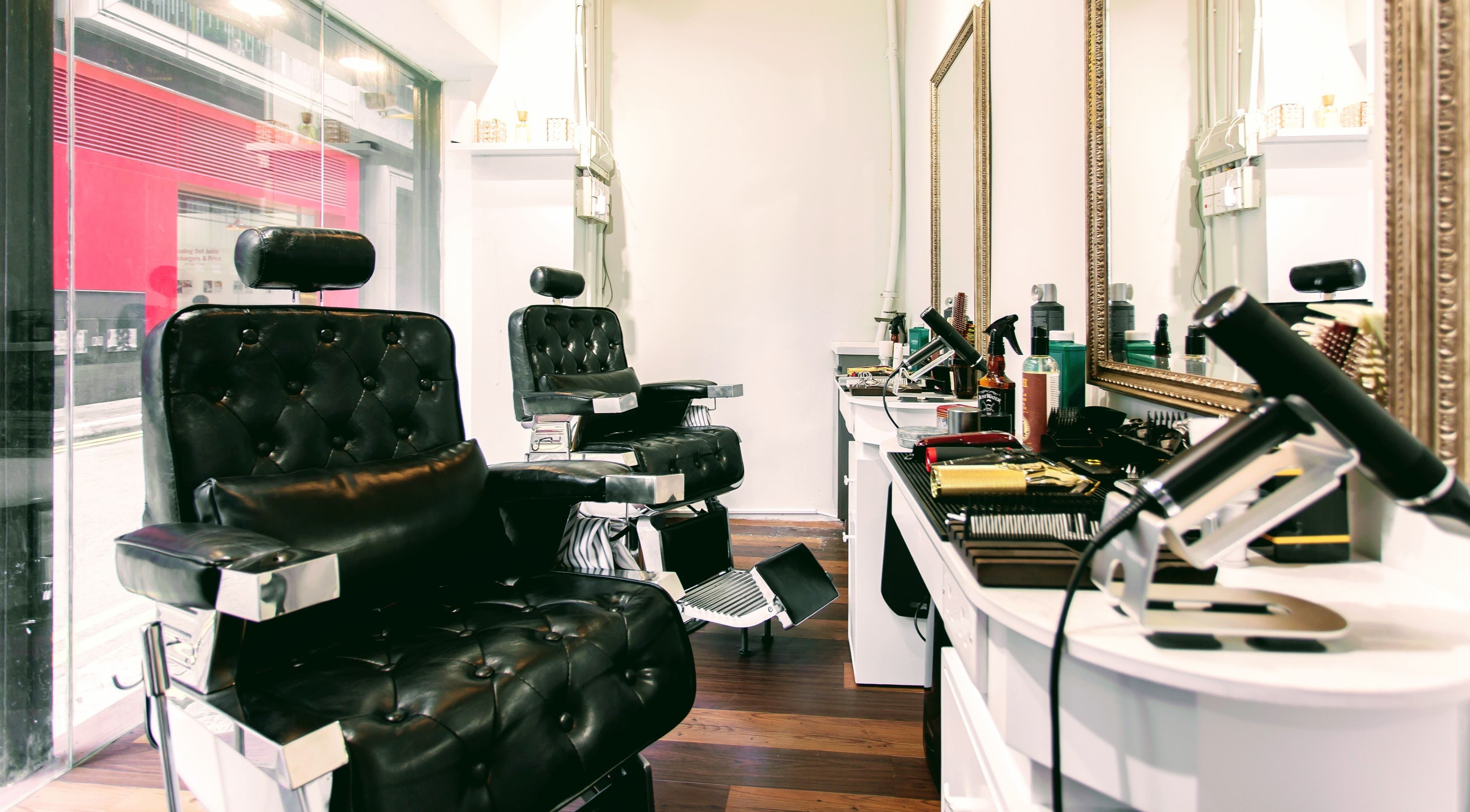 Elegant barber chairs at Fade Zone, 香港島, 香港島, HK, with grooming tools on sleek counters.