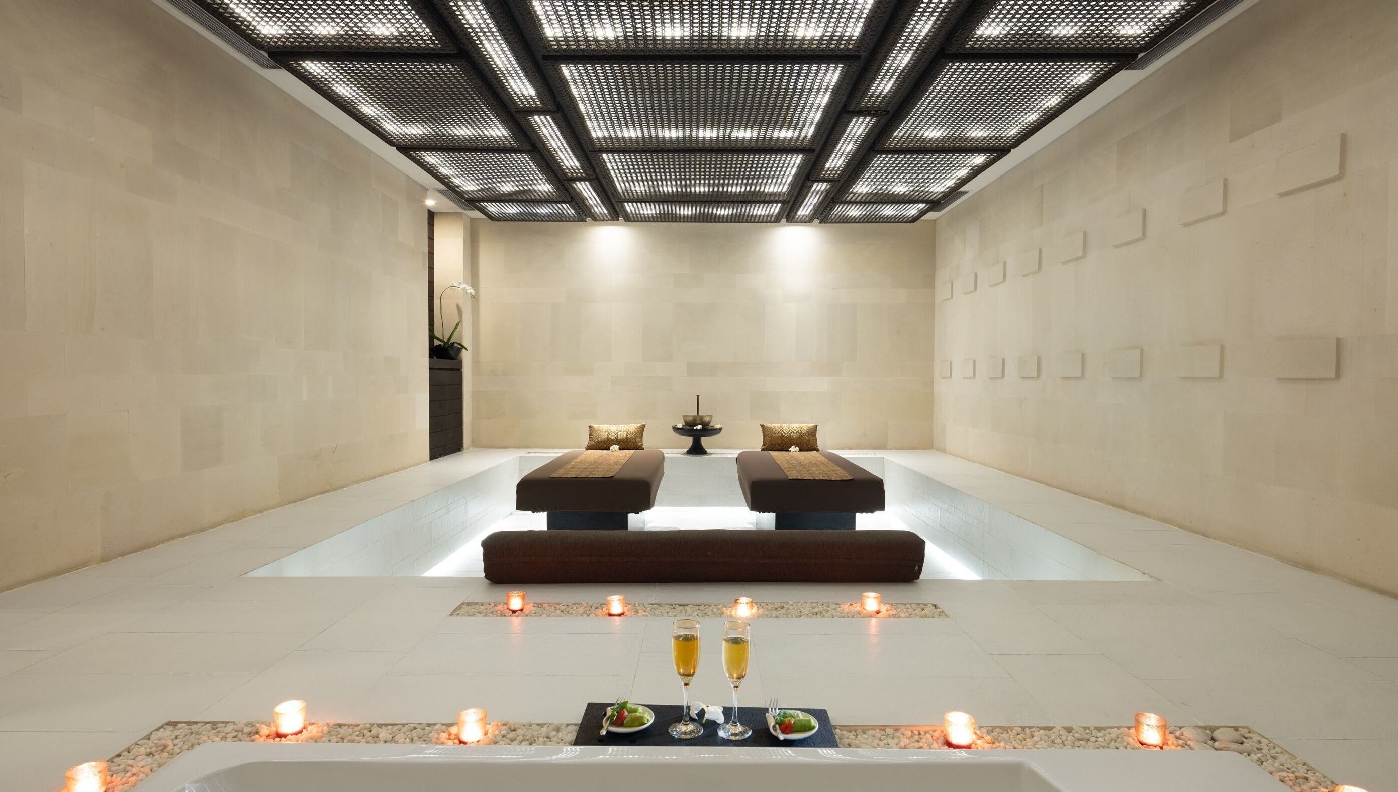 Luxurious massage beds at eqUALIZE Spa in Kuta Utara, Bali, ID, surrounded by candles for relaxation.