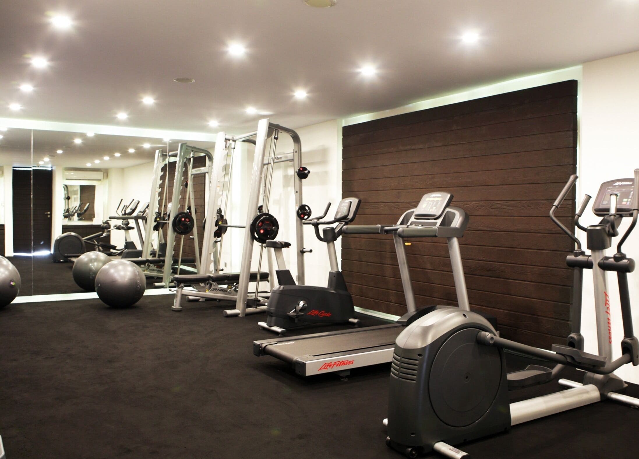 Modern fitness equipment at eqUALIZE Spa, Kuta Utara, Bali, ID, in a well-lit, spacious room.