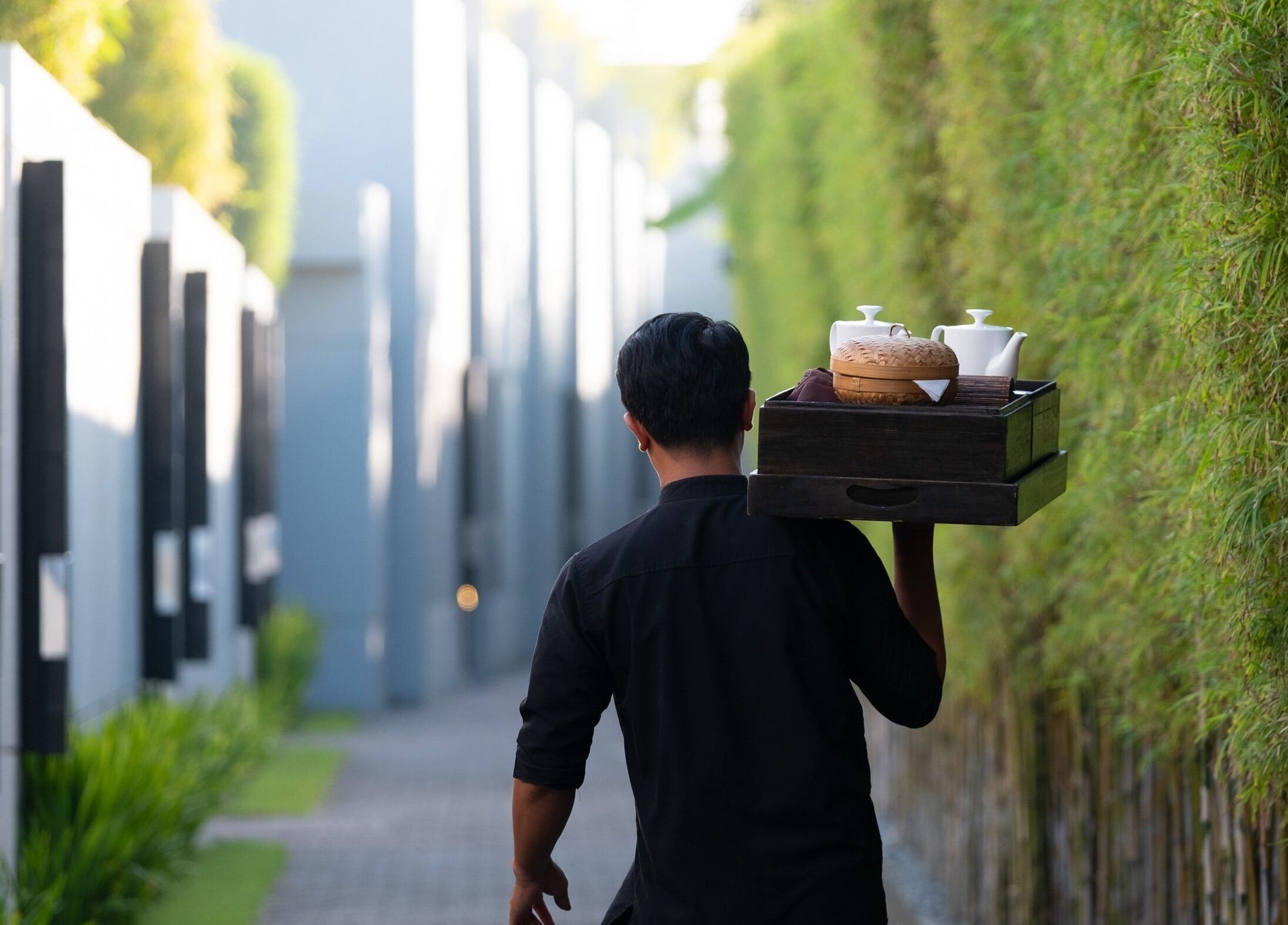 Staff carrying tray at eqUALIZE Spa, Kuta Utara, Bali, ID, showcasing serene luxury experience.