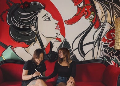 Guests enjoy the artistic lounge at RedDoors, Bali, Bali, ID, featuring vibrant mural art and cozy seating.