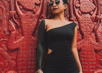 Stylish person in black dress posing against ornate red door at RedDoors, Bali, Bali, ID.
