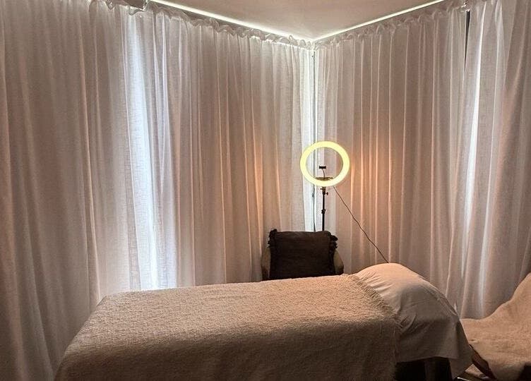 Комната для массажа лица в Facial Massage, Сидней, Новый Южный Уэльс, AU с мягким освещением и удобной кушеткой.