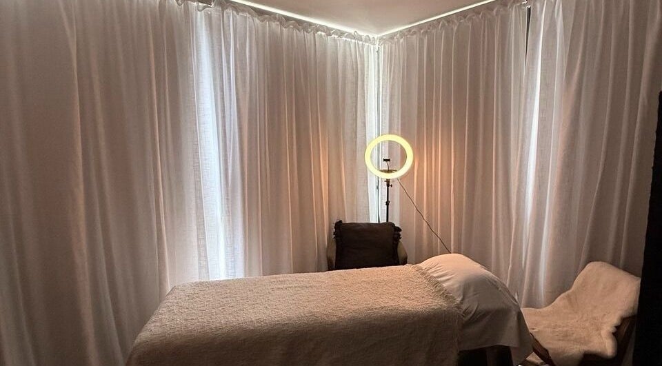 Комната для массажа лица в Facial Massage, Сидней, Новый Южный Уэльс, AU с мягким освещением и удобной кушеткой.