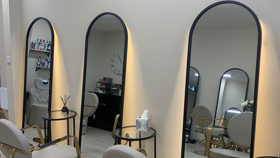 Chic interior of Hair by Sophie Ambrey, New Mills, England, GB with modern salon mirrors and sleek chairs.