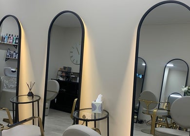 Chic interior of Hair by Sophie Ambrey, New Mills, England, GB with modern salon mirrors and sleek chairs.