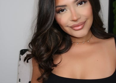Smiling woman inside Mysa Studio, Orpington, England, GB showcasing flawless makeup and radiant beauty.