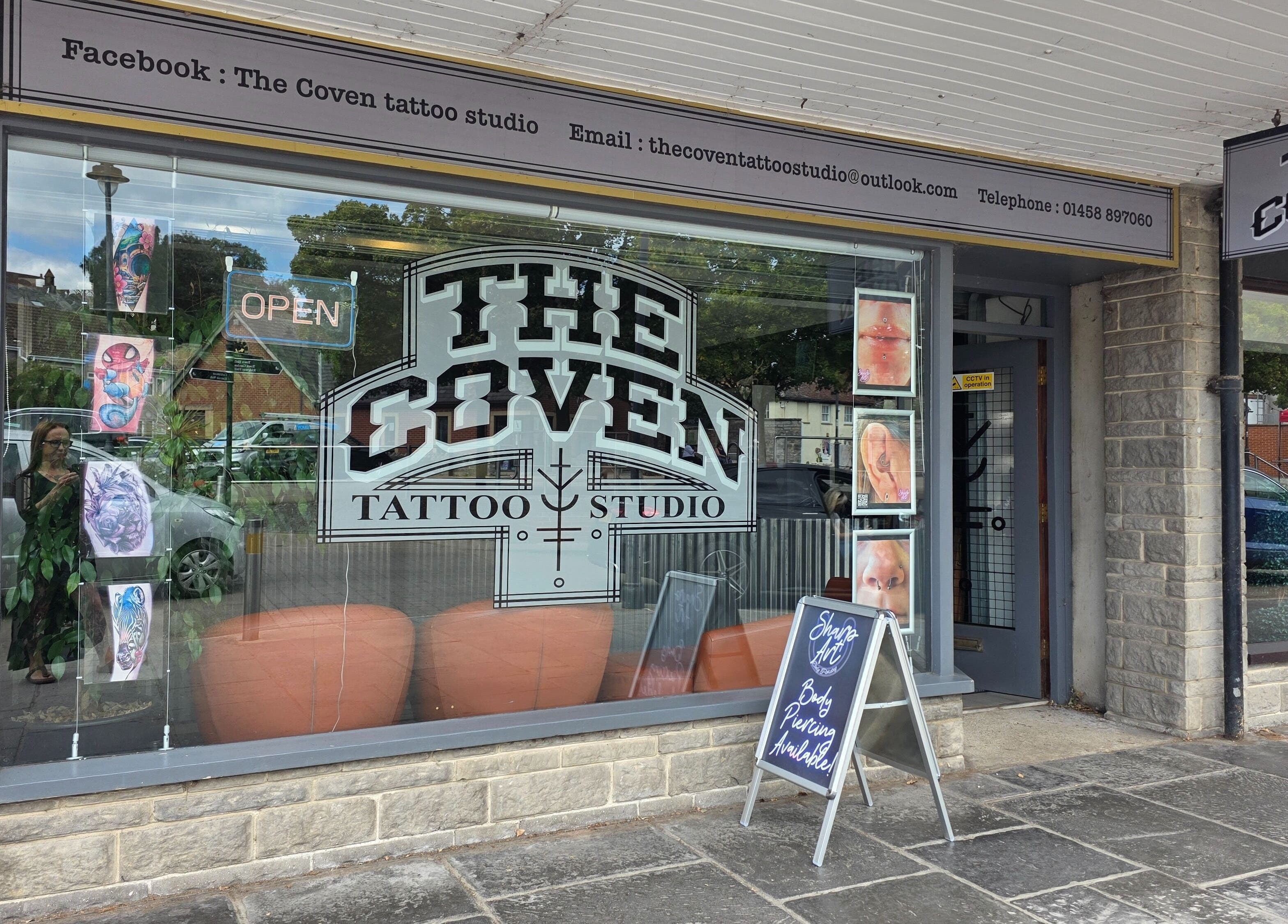 The Coven Tattoo Studio exterior showcasing art and signage for Sharp Art Body Piercing in Langport, England, GB.